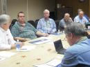 Dennis Dura, K2DCD (far left), leads a discussion on emergency communications in the conference room at ARRL Headquarters. (Left to right): Dennis Dura, K2DCD; Tom Brehmer, N0LOH; Mike Neilsen, W1MPN; J.M. Rowe, N5XFW; Dean Feken, KL7MA; Garth Crowe, N7XKT, and Mike Lisenco, N2YBB (in the foreground, bottom right). [Chuck Skolaut, K0BOG, Photo]